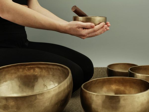 Close-up of hands and feet in a specific yoga position.
